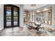 A dining room featuring a large dining table, designer chandelier and stone tile flooring at 8388 Catamaran Cir, Lakewood Ranch, FL 34202