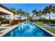 Backyard pool featuring a blue interior, green grass, landscaping, and chaise lounges at 8388 Catamaran Cir, Lakewood Ranch, FL 34202