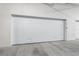 Modern white garage door featuring a sleek, minimalist design and concrete floors at 111 Golden Gate Pt # 701Ph, Sarasota, FL 34236