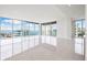 Bright, open living room with floor-to-ceiling windows and stunning water views, perfect for modern living at 111 Golden Gate Pt # 701Ph, Sarasota, FL 34236
