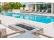 Community pool area with a fire pit and several lounge chairs for residents to enjoy at 111 Golden Gate Pt # 701Ph, Sarasota, FL 34236