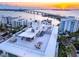 Aerial view of the rooftop terrace with a bar, multiple seating, lounge chairs, and ocean views at 111 Golden Gate Pt # 701Ph, Sarasota, FL 34236