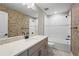 Modern bathroom with a white shower, gray vanity, and vibrant, artistic wallpaper at 12409 Wigeon Dr, Bradenton, FL 34212