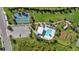 Aerial view of community pool, tennis court, parking, playground, and green space at 2028 Woodleaf Hammock Ct, Bradenton, FL 34211
