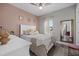 Inviting bedroom with soft pink accents, comfortable bed, and a cozy atmosphere at 2028 Woodleaf Hammock Ct, Bradenton, FL 34211