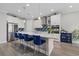 Spacious kitchen featuring a large island, quartz countertops, stainless steel appliances, and a mosaic tile backsplash at 2028 Woodleaf Hammock Ct, Bradenton, FL 34211