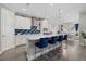 Elegant kitchen with a large island, white cabinetry, stainless steel appliances, and stylish blue backsplash at 2028 Woodleaf Hammock Ct, Bradenton, FL 34211