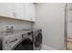 Well-equipped laundry room with modern LG washer and dryer, and ample cabinet storage at 2028 Woodleaf Hammock Ct, Bradenton, FL 34211