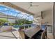 Screened outdoor kitchen featuring stainless steel grill, granite counters, and a stylish ceiling fan overlooking the pool at 2028 Woodleaf Hammock Ct, Bradenton, FL 34211