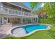 Inviting backyard oasis featuring a pool, putting green, covered patio, and lush landscaping at 203 72Nd St, Holmes Beach, FL 34217