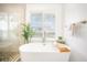 Bright bathroom features a luxurious soaking tub, walk-in shower, and a window providing natural light at 203 72Nd St, Holmes Beach, FL 34217