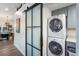 Convenient laundry area with stacked washer and dryer, adjacent to a stylish sliding glass door at 203 72Nd St, Holmes Beach, FL 34217