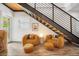 Cozy sitting area beneath a staircase with stylish chairs, ottomans, and modern decor at 203 72Nd St, Holmes Beach, FL 34217
