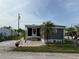 Charming single-story home with a screened-in porch, brick patio, and lush green lawn at 2601 Gulf N Dr # S2, Bradenton Beach, FL 34217