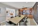 Dining room features a wood table, grey chairs, built-in shelving, and open access to a kitchen with modern appliances at 6310 Watercrest Way # 201, Lakewood Ranch, FL 34202
