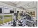 Bright fitness center with modern equipment, televisions, and large windows offering scenic lake views for an inspiring workout at 6310 Watercrest Way # 201, Lakewood Ranch, FL 34202