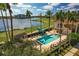 Aerial view of a refreshing swimming pool surrounded by palm trees, lush landscaping, and lounge chairs at 6310 Watercrest Way # 201, Lakewood Ranch, FL 34202
