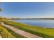 Scenic water view with a paved path and lush green grass at 6310 Watercrest Way # 201, Lakewood Ranch, FL 34202