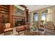 Cozy living room with a fireplace, built-in bookshelves, and natural light from arched windows with ocean view at 3625 Casey Key Rd, Nokomis, FL 34275