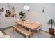 Bright dining room with wooden table, bench seating, modern decor and an open view to the kitchen at 3682 Lake Bayshore Dr # K402, Bradenton, FL 34205