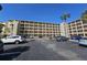 Spacious condo building featuring multiple balconies, palm trees, and ample parking at 3682 Lake Bayshore Dr # K402, Bradenton, FL 34205