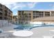 Outdoor pool with surrounding lounge furniture and condo buildings in the background at 3682 Lake Bayshore Dr # K402, Bradenton, FL 34205