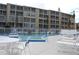 Outdoor pool surrounded by lounge chairs and tables, with condominium buildings nearby at 3682 Lake Bayshore Dr # K402, Bradenton, FL 34205