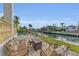 Waterfront backyard featuring outdoor seating, a fire pit, and well-manicured lawn at 550 Yardarm Ln, Longboat Key, FL 34228