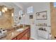 Bathroom featuring tile flooring, wood cabinets, granite countertop, and dual vanity at 550 Yardarm Ln, Longboat Key, FL 34228