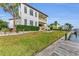 Home exterior with a well-manicured lawn, a dock, and an outdoor dining area at 550 Yardarm Ln, Longboat Key, FL 34228