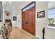 Bright foyer with large wood front doors, tile floors, and staircase leading to the second floor at 550 Yardarm Ln, Longboat Key, FL 34228