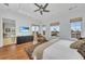 Bright primary bedroom featuring hardwood floors, a chaise lounge, and serene views at 550 Yardarm Ln, Longboat Key, FL 34228