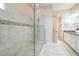 Elegant bathroom featuring a glass-enclosed shower, neutral tile, and dual vanity sinks at 12826 Sorrento Way, Bradenton, FL 34211