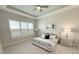 Bright bedroom featuring a ceiling fan, tray ceiling, neutral walls, and large windows with custom shutters at 12826 Sorrento Way, Bradenton, FL 34211