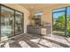 Covered outdoor kitchen features modern stainless steel appliances and sliding glass doors to the interior at 12826 Sorrento Way, Bradenton, FL 34211