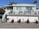 Charming elevated home featuring a covered porch with bright blue chairs, perfect for relaxing outdoors at 2601 Gulf N Dr # 528, Bradenton Beach, FL 34217