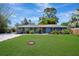 Charming single-story home with a well-manicured lawn, lush landscaping, and a blue exterior at 3902 11Th W Ave, Bradenton, FL 34205
