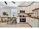 Charming kitchen with white cabinets, wood counters, and stainless steel appliances, plus a cozy dining area at 3902 11Th W Ave, Bradenton, FL 34205