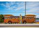 Bus turned surf shop, adorned with paddles and surfboards, parked by the water at 3902 11Th W Ave, Bradenton, FL 34205