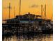 Waterfront restaurant at sunset with illuminated signage and boats docked nearby at 3902 11Th W Ave, Bradenton, FL 34205