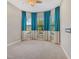 Bright bedroom with bay windows and blue drapes, offering a lovely view and natural light at 4020 Cascina Way, Sarasota, FL 34238
