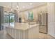 Bright kitchen featuring stainless steel appliances, a large island, and sliding doors leading to the outdoor area at 4020 Cascina Way, Sarasota, FL 34238