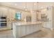 Beautiful kitchen island with white cabinetry, pendant lighting, mosaic backsplash, and stainless steel appliances at 4020 Cascina Way, Sarasota, FL 34238
