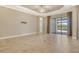 Spacious living room with neutral colors, tile flooring, and sliding glass doors to outdoor pool area at 4020 Cascina Way, Sarasota, FL 34238