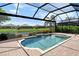 Inviting screened-in pool with waterfall feature, set against a serene lake backdrop with lush landscaping at 4020 Cascina Way, Sarasota, FL 34238