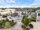 Stunning aerial view of a luxurious two-story home with a tile roof, paver driveway, and lush landscaping, with lake view at 7716 Club Ln, Sarasota, FL 34238