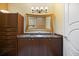 Bathroom with dark wood cabinetry, and a large, framed mirror above a sink and marble counter at 7716 Club Ln, Sarasota, FL 34238
