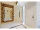 Bright foyer features a decorative mirror, tiled floor, and white front door, creating a welcoming entrance at 7716 Club Ln, Sarasota, FL 34238