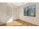 Bright bedroom with hardwood floors, large window, and closet with shutter doors at 1774 10Th St, Sarasota, FL 34236