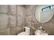 Modern bathroom featuring stylish gray tiling and a round mirror above a sleek sink at 1778 10Th St, Sarasota, FL 34236